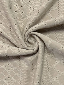 Nahaufnahme von beigem Strickstoff mit hohlem Rautenmuster und atmungsaktiver Jacquard-Struktur