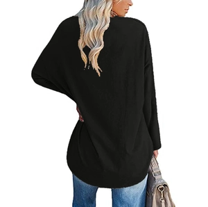Detail view of the relaxed fit and curved hem of a black long-sleeve heart print top