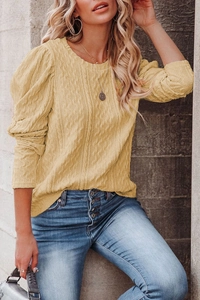 Detailed texture of ginger yellow cable knit sweater with elegant puff sleeve design