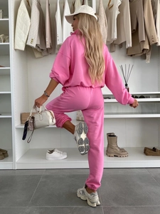 Détail d'un survêtement en coton rose avec un sweat à capuche ample et un pantalon de jogging