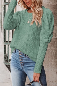 Detailed view of sage green cable-knit sweater with premium textured knit pattern
