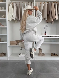 Détail d'un survêtement en tricot gris clair avec sweat à col montant et pantalon de jogging