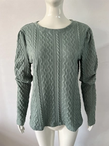 Close-up of sage green cable knit texture and crewneck design on long sleeve sweater