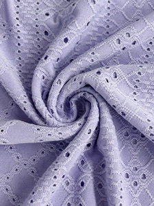 Detail of light purple broderie anglaise fabric with diamond texture and eyelet patterns