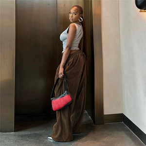 Close-up of high-waist corduroy wide-leg pants paired with a grey tank top and shoulder bag