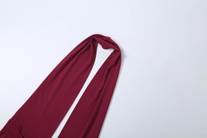 Detail of wine red halter dress with silky elastic fabric and subtle glossy texture