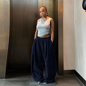 Detail of high-waisted navy blue corduroy wide-leg pants showing the vertical stripe texture
