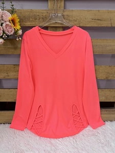 Detail of V-neck long sleeve top in neon coral with stylish hollow lace-up side hem design