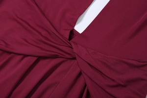 Detail view of the twisted crossover neckline and drapery on a burgundy sexy dress