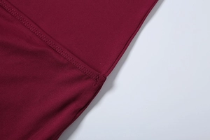 Detail view of double stitching on burgundy fabric with a subtle lustrous texture