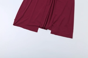 Detail of burgundy evening dress with high split and soft knitted fabric texture