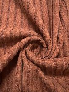 Détail de la texture du tricot côtelé marron rouge pour robe d'automne à manches longues