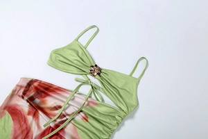 Detail of green floral dress with gold flower ornament and elegant waist tie-up
