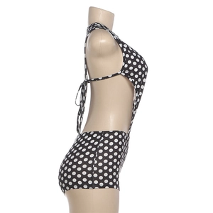 Side view of polka dot high-waisted swimsuit showing cut-out waist and lace-up back detail