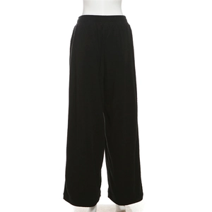 Detailed view of black corduroy high-waisted wide-leg trousers on a display mannequin