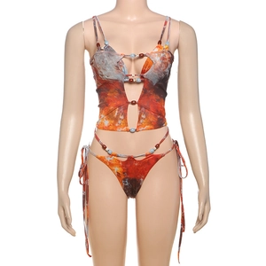 Detail of printed bikini top with blue bead accents and strappy tie-up cutout design