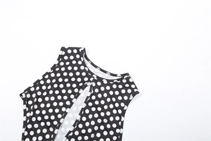 Close-up of polka dot fabric with vertical chest cutout and round neckline detail