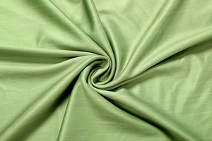 Detailed texture of light green woven fabric showing soft drape and fine textile quality