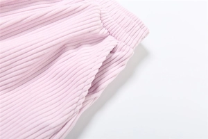 Detail of high waist corduroy pants featuring elastic waistband and side pocket
