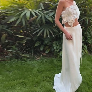 Detail of white two-piece set featuring 3D floral sequins top and silk maxi skirt