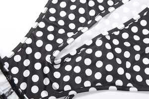 Close-up of polka dot fabric detail with a circular cutout on black bodysuit