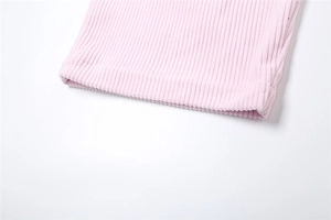 Close-up of pink corduroy fabric texture and neat stitching on casual wide-leg trousers