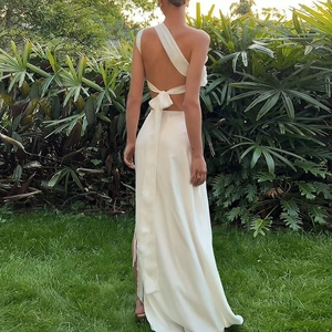 Elegant white satin backless dress featuring a large decorative bow and long flowing train