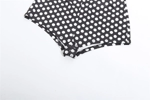 Close-up of the stitching and leg opening on these black and white polka dot bodysuits