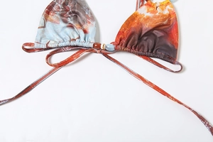 Detailed macro of marble print bikini top with decorative beads and halter neck ties