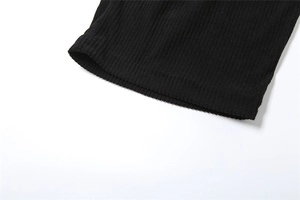 Close-up of black ribbed knit fabric detail showing the fine vertical stripe texture