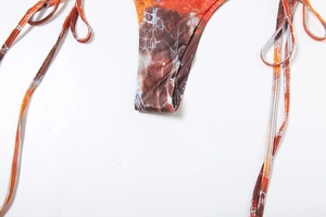 Detailed view of bikini bottom with abstract marble print and side tie strings