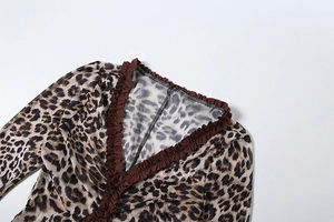 Detail of leopard print jumpsuit featuring a V-neckline with brown ruffled trim edges