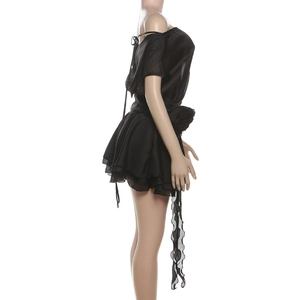 Vue détaillée de la fleur 3D à la taille et de l'ourlet à volants de cette robe noire