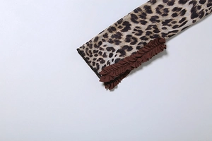 Close-up of leopard print sheer mesh fabric with ruffled edges and fine stitching