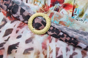 Dettaglio tessuto mesh leopardato e floreale tropicale con anello intrecciato