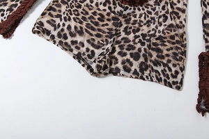 Detail of leopard print fabric with dark brown ruffle trim and sheer knit texture