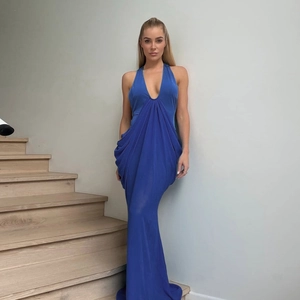 Detail view of royal blue pleated evening dress with halter neck and deep V-neckline texture