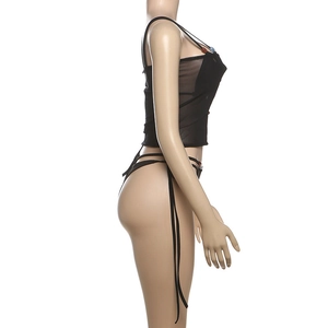 Detail of sheer black mesh bikini set with decorative beads on straps and lightweight fabric