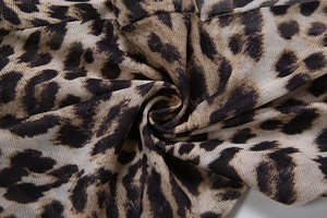 Detailed macro view of sheer leopard print mesh fabric with soft breathable texture