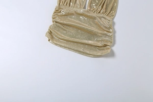 Dettaglio ravvicinato del tessuto metallico dorato arricciato con finitura scintillante