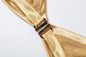 Détail macro du tissu de bikini en satin doré avec fermoir métallique poli
