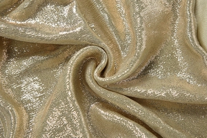 Dettaglio macro del tessuto metallico dorato lucido con finitura testurizzata brillante