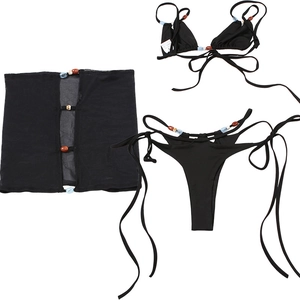 Detailed view of black three-piece bikini set with mesh cover-up and bohemian beads