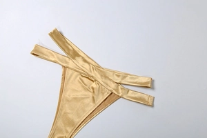 Détail du bas de bikini doré brillant avec doubles lanières croisées à la taille