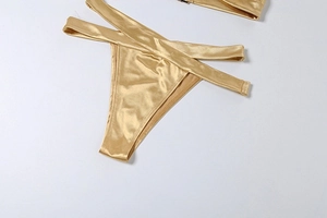 Détail macro du bas de bikini doré métallisé sexy avec lanières croisées à la taille