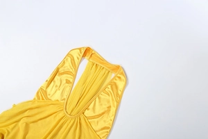 Detail of yellow satin halter dress showing V-neckline and elegant pleated texture