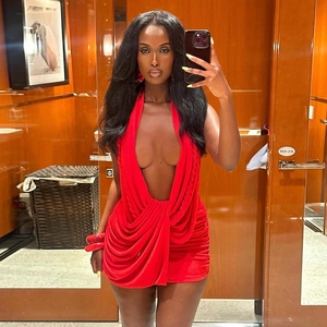 Close-up of red mini dress featuring deep V-neckline, halter neck, and ruched fabric detail