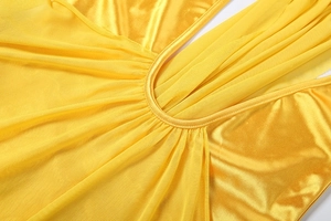 Detail of bright yellow dress showing satin pleats and sheer mesh paneling seams