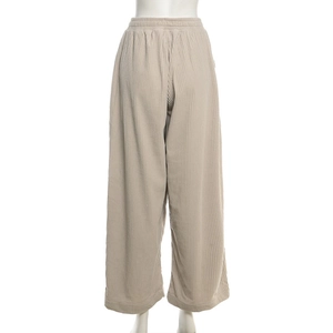 Detail of high-waist beige corduroy wide-leg pants showing elastic waist and ribbed texture