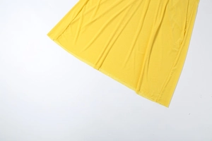 Detail of bright yellow dress showing lightweight pleated texture and draped fabric finish
